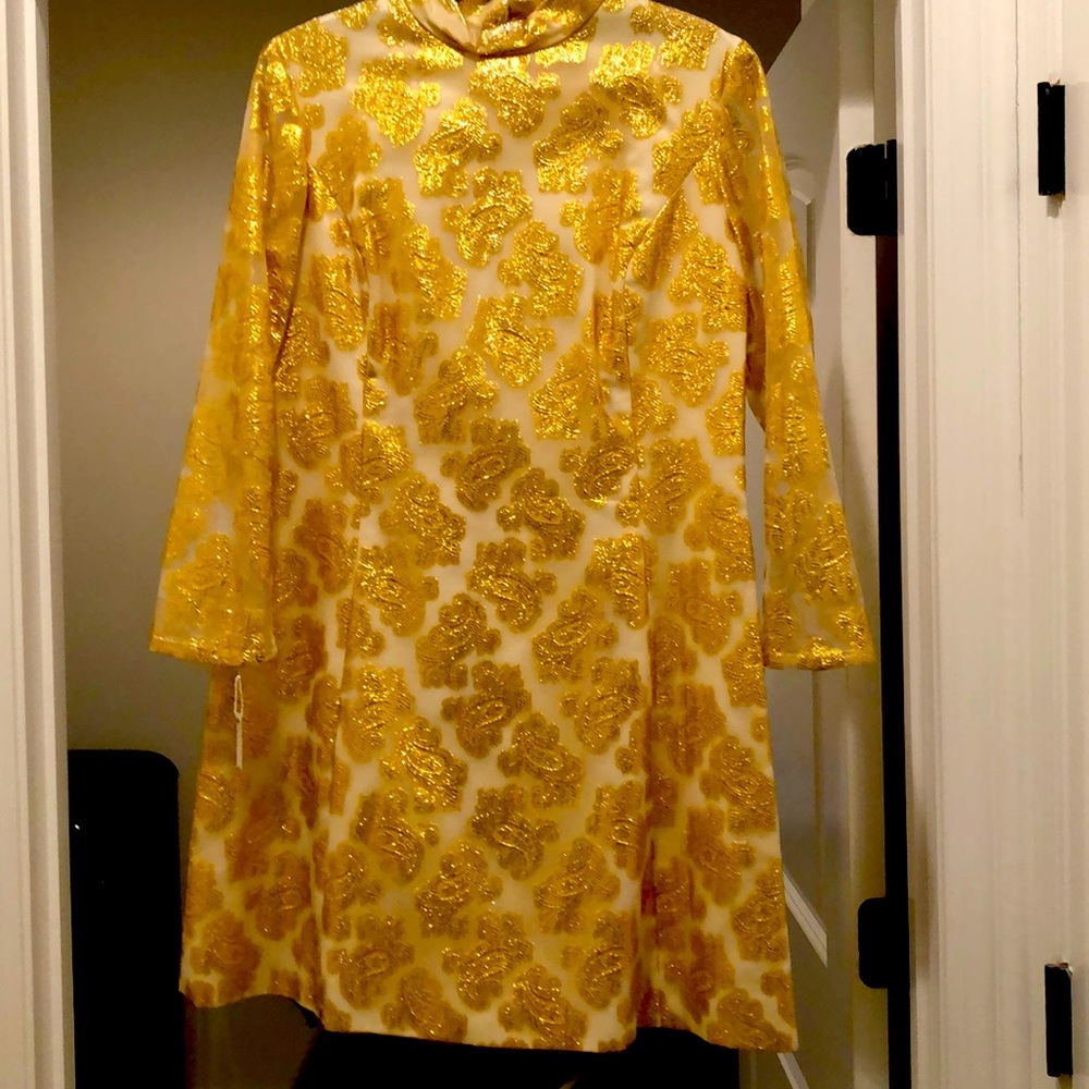 A 1960 gold and cream shift dress above the knee.